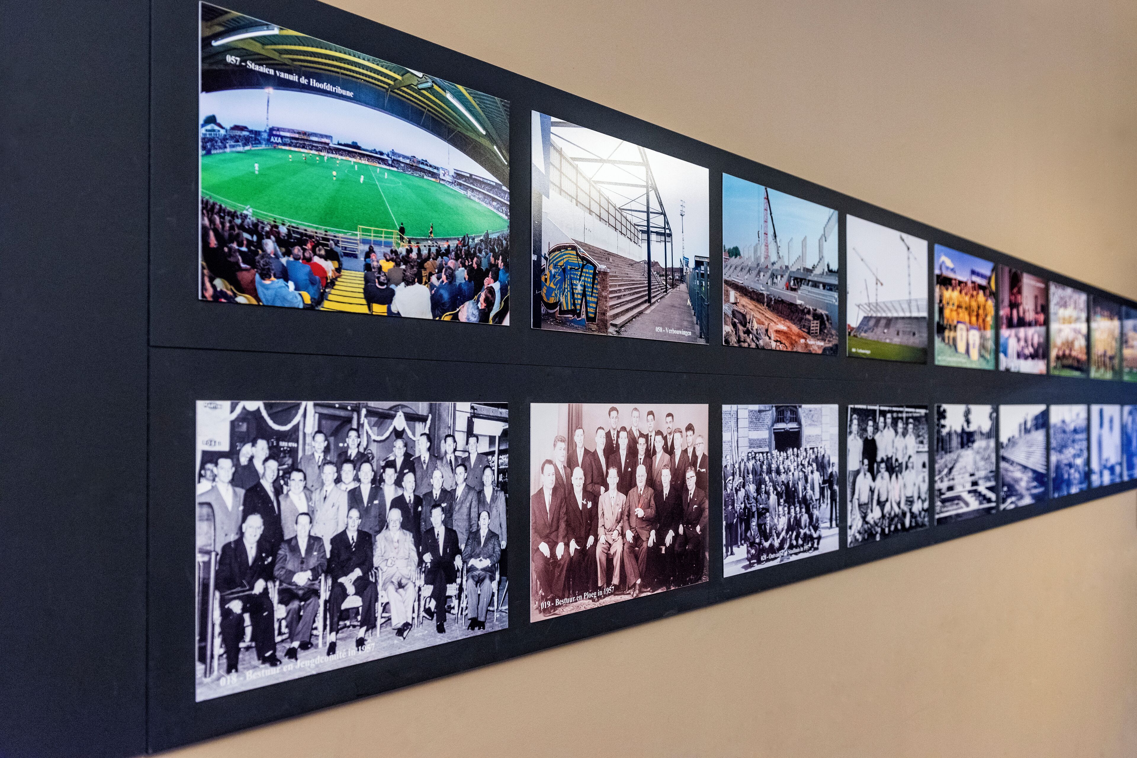 Una pared exhibe una serie de fotografías históricas, incluyendo un estadio, estructuras industriales y eventos formales.