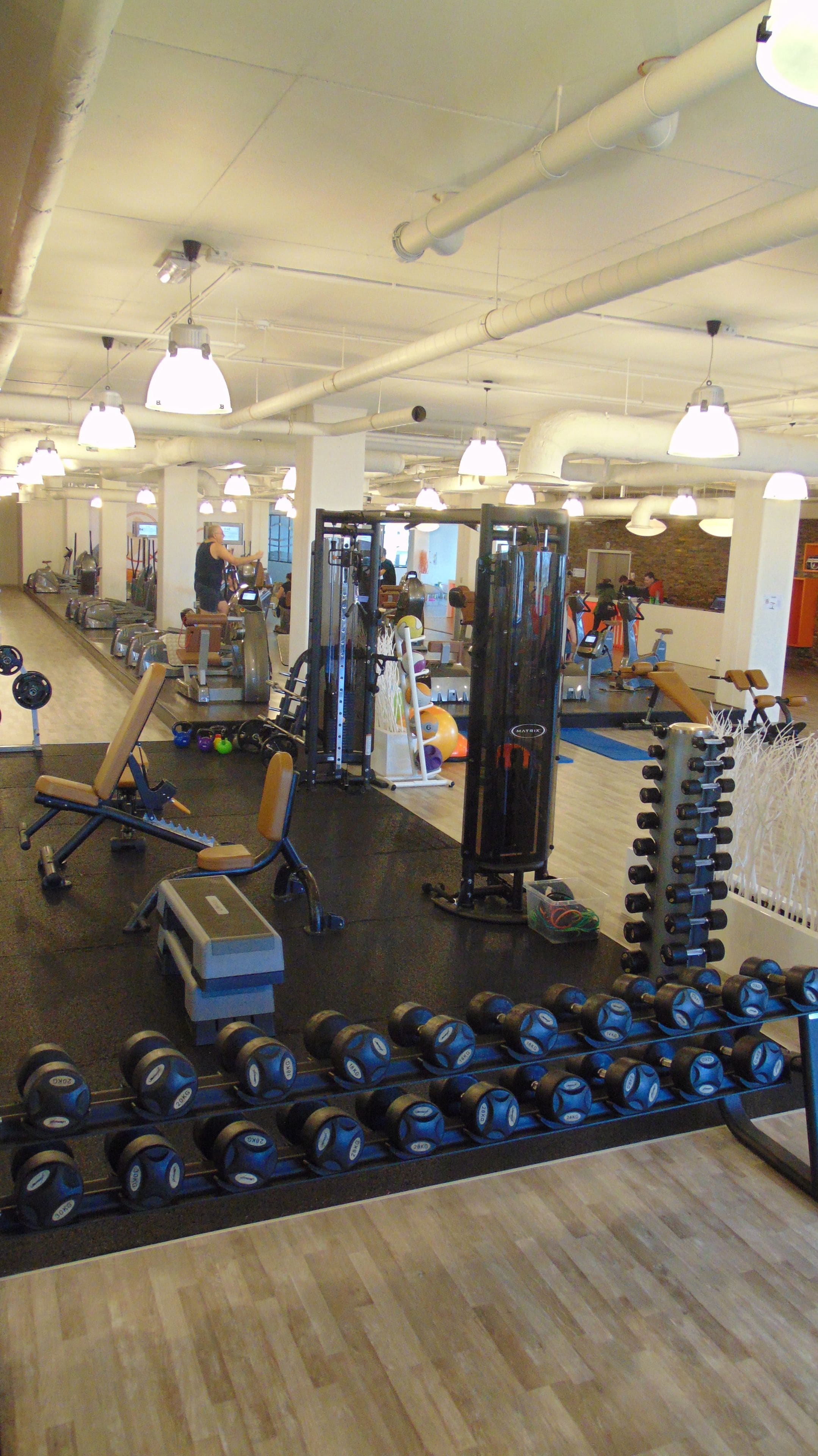 A gym with various exercise equipment, including dumbbells and weight machines.