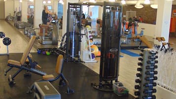 A gym with various exercise equipment, including dumbbells and weight machines.