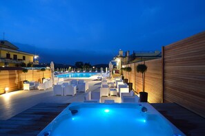 A pool area with lounge chairs and a hot tub, surrounded by wooden walls and a view of the pool. - Hotel Ristorante Dante (Torgiano)