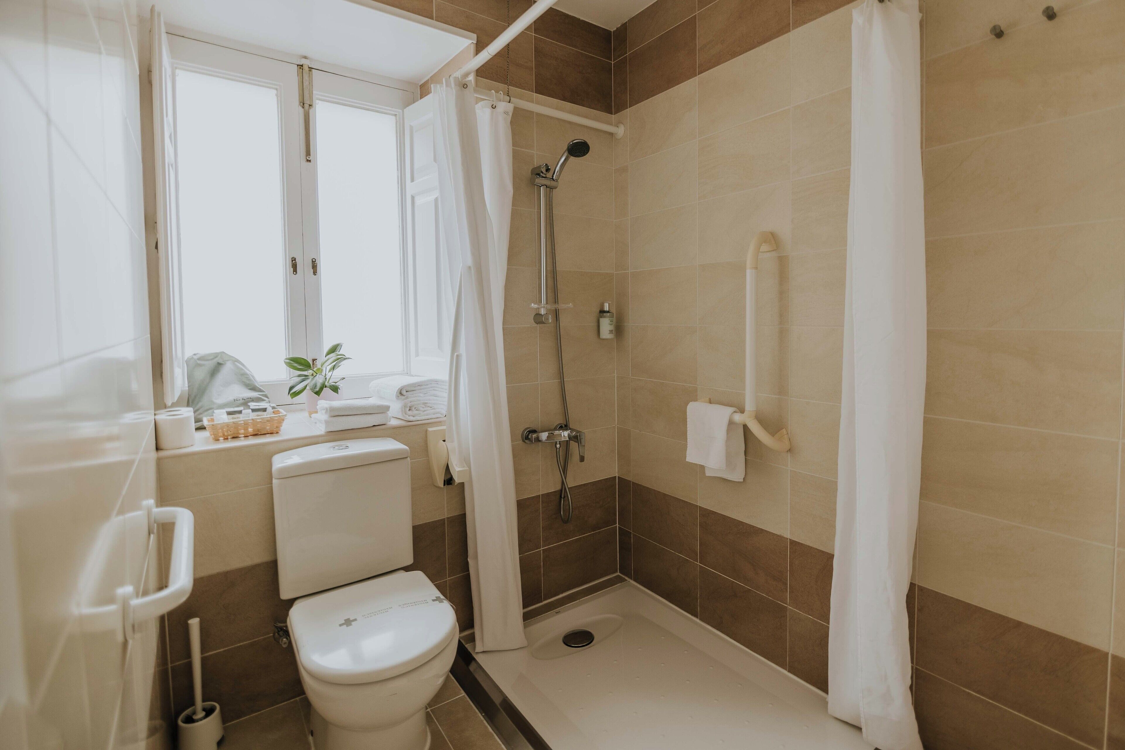 Een moderne badkamer met douche, toilet en wastafel.