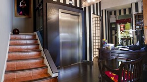A modern interior with a staircase, elevator, and a desk area with a chair. - Hotel Arrope (Haro)