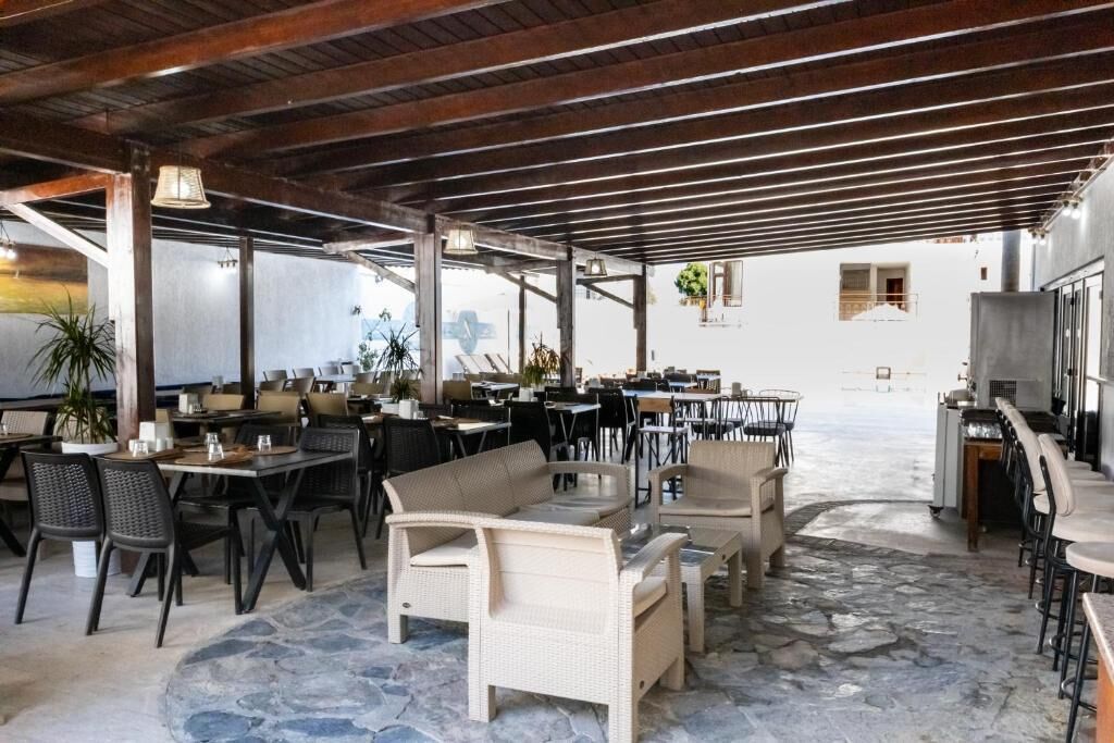 An outdoor dining area with stone flooring, wicker furniture, and a view of the street.