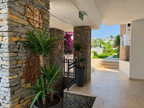 A stone wall with potted plants, a metal gate, and a clear view of the outside. - Salinas Beach Hotel Bodrum/Boutique Concept  (Bodrum)