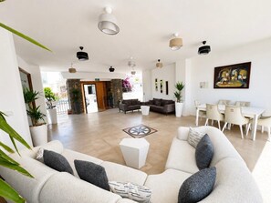 A spacious lobby with a sofa, dining area, and potted plants. - Salinas Beach Hotel Bodrum/Boutique Concept  (Bodrum)