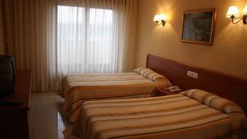 Una habitación de hotel con dos camas, un televisor y un cuadro en la pared.