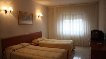 Habitación de hotel con dos camas, un televisor y un cuadro en la pared.