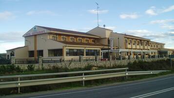 Hotel with a symmetrical facade and central entrance, surrounded by a secure perimeter.