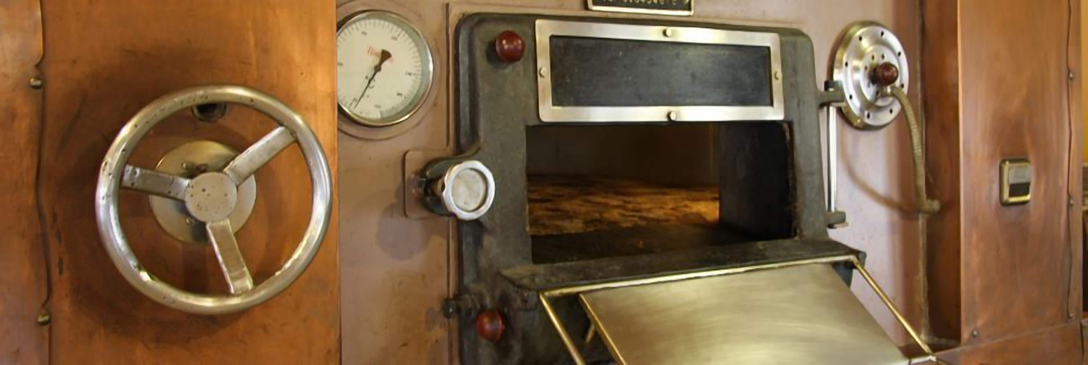 Un panel de control antiguo con un volante, indicadores y un panel con botones y una pantalla.