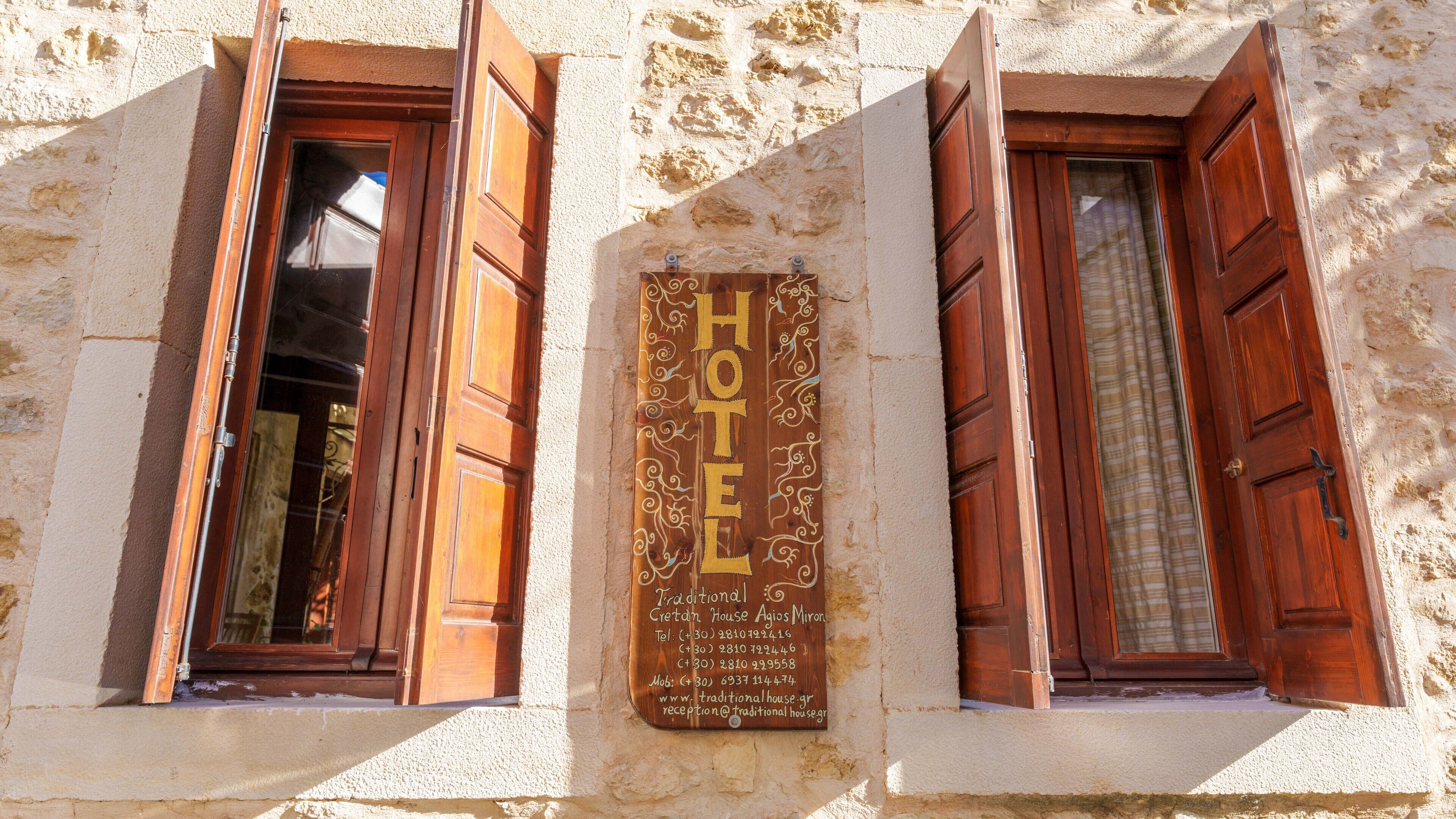 Ein traditionelles Haus mit einem hölzernen Schild, das es als Hotel kennzeichnet.