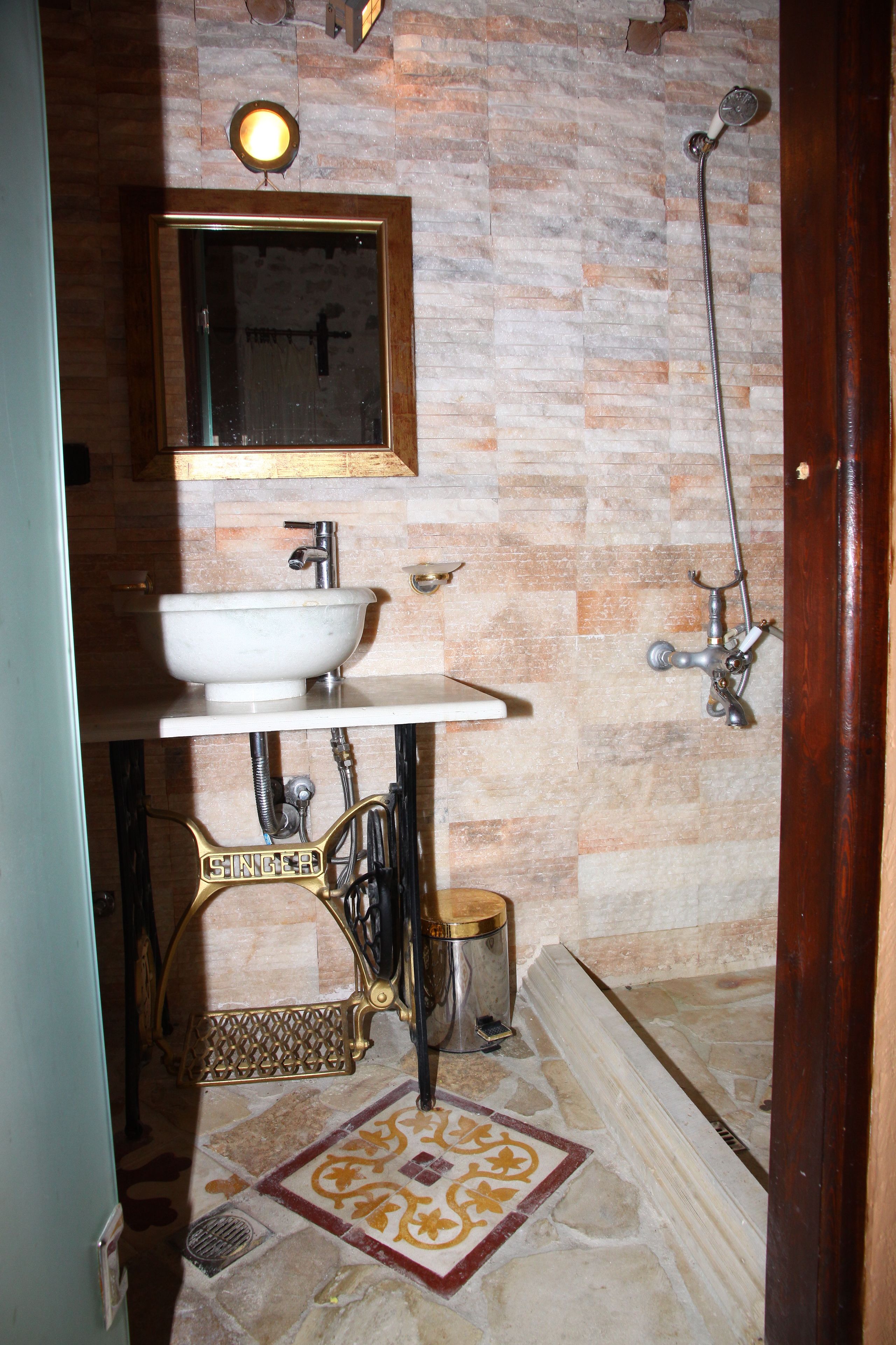 Baño con lavamanos, espejo y ducha.