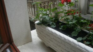 A white planter box with red flowers on a balcony. - Palace Stafileo (Trogir)