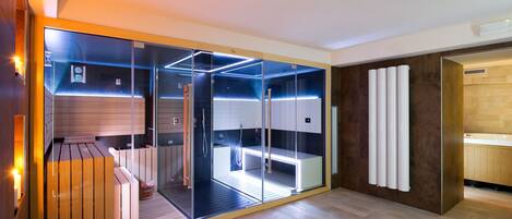 A modern bathroom with a glass enclosure, wooden flooring, and a built-in bench.