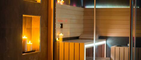 A sauna with wooden benches and a glass partition.