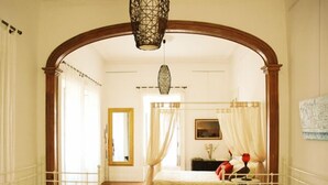 Quarto com cama de dossel, arco de madeira e luminária pendente.