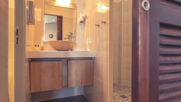 A modern bathroom with a wooden vanity, a large mirror, and a shower area.