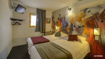 Habitación de hotel con dos camas, un televisor de pantalla plana, un cuadro en la pared y una ventana con cortinas.