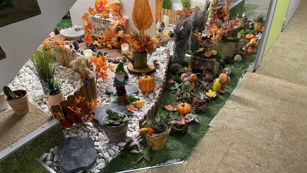 A garden display with autumn leaves, pumpkins, and various plants. - The Originals Access Bourges Nord (Saint-Doulchard)