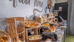 A buffet setup with various food items and baskets. - The Originals Access Bourges Nord (Saint-Doulchard)