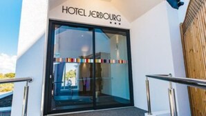 The entrance to Hotel Jerbourg with a modern design, featuring a glass facade and metal railings. - Hotel Jerbourg (St. Martins)