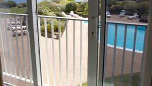 A balcony with a view of a swimming pool and a landscaped garden. - Hotel Jerbourg (St. Martins)