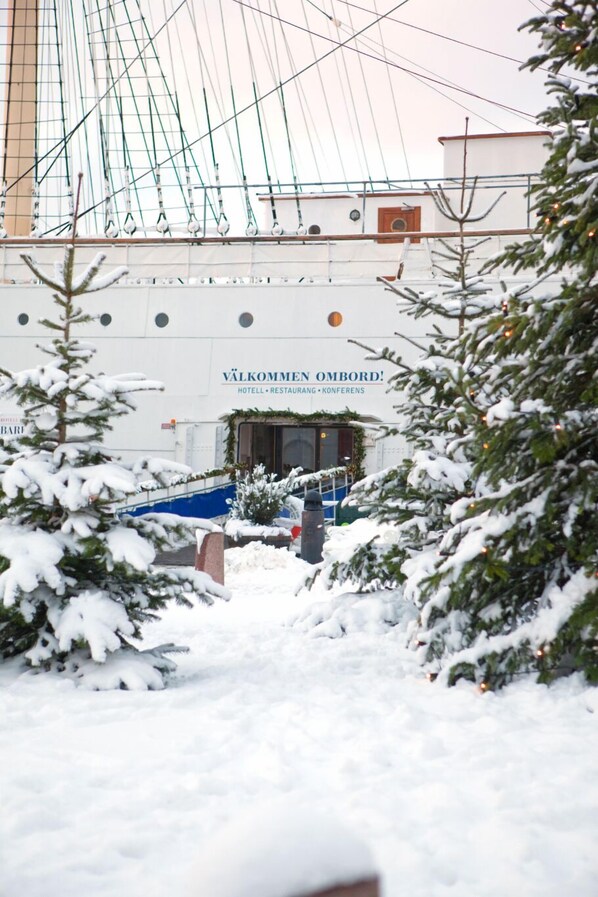 Un espace extérieur enneigé, avec un bâtiment portant l’inscription « Välkommén Ombord » en arrière-plan.