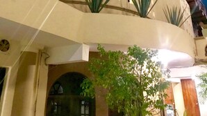 Un edificio con techo de paja, varios balcones y un espacio central abierto con techo de vidrio.