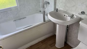 Un baño con bañera, lavamanos e inodoro.