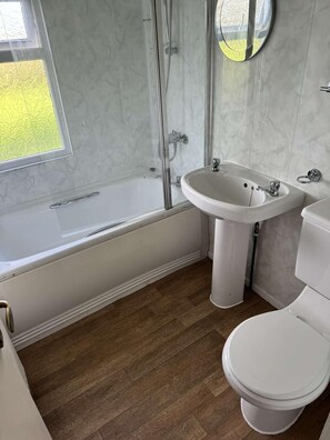 A bathroom with a bathtub, a sink, and a toilet.