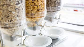 A food dispensing station with multiple containers of granola and cereal.