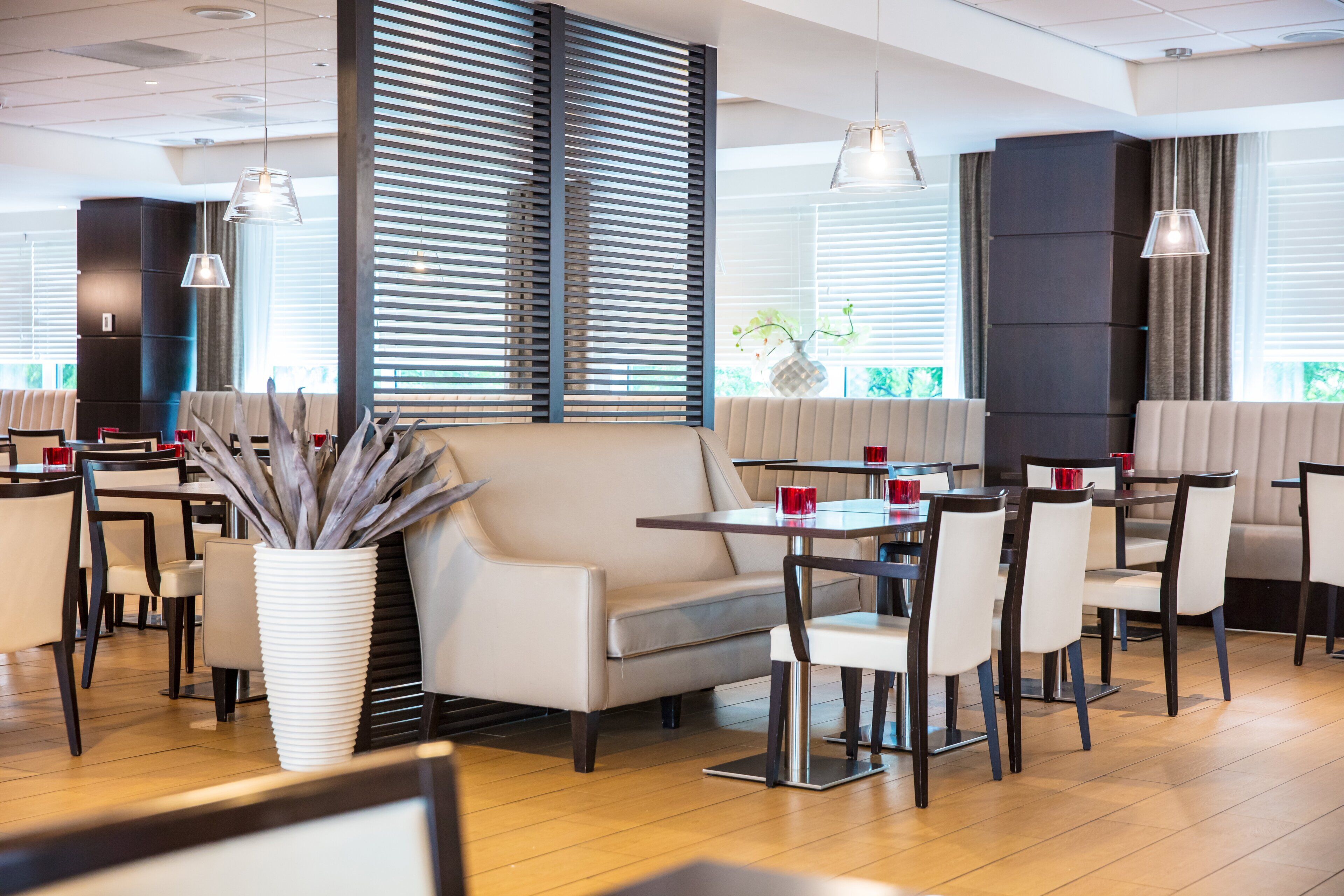 A modern restaurant interior with seating arrangements, tables, and decorative elements.