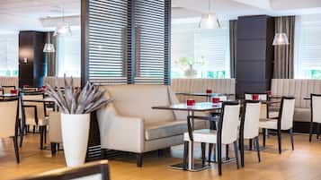 A modern restaurant interior with seating arrangements, tables, and decorative elements.