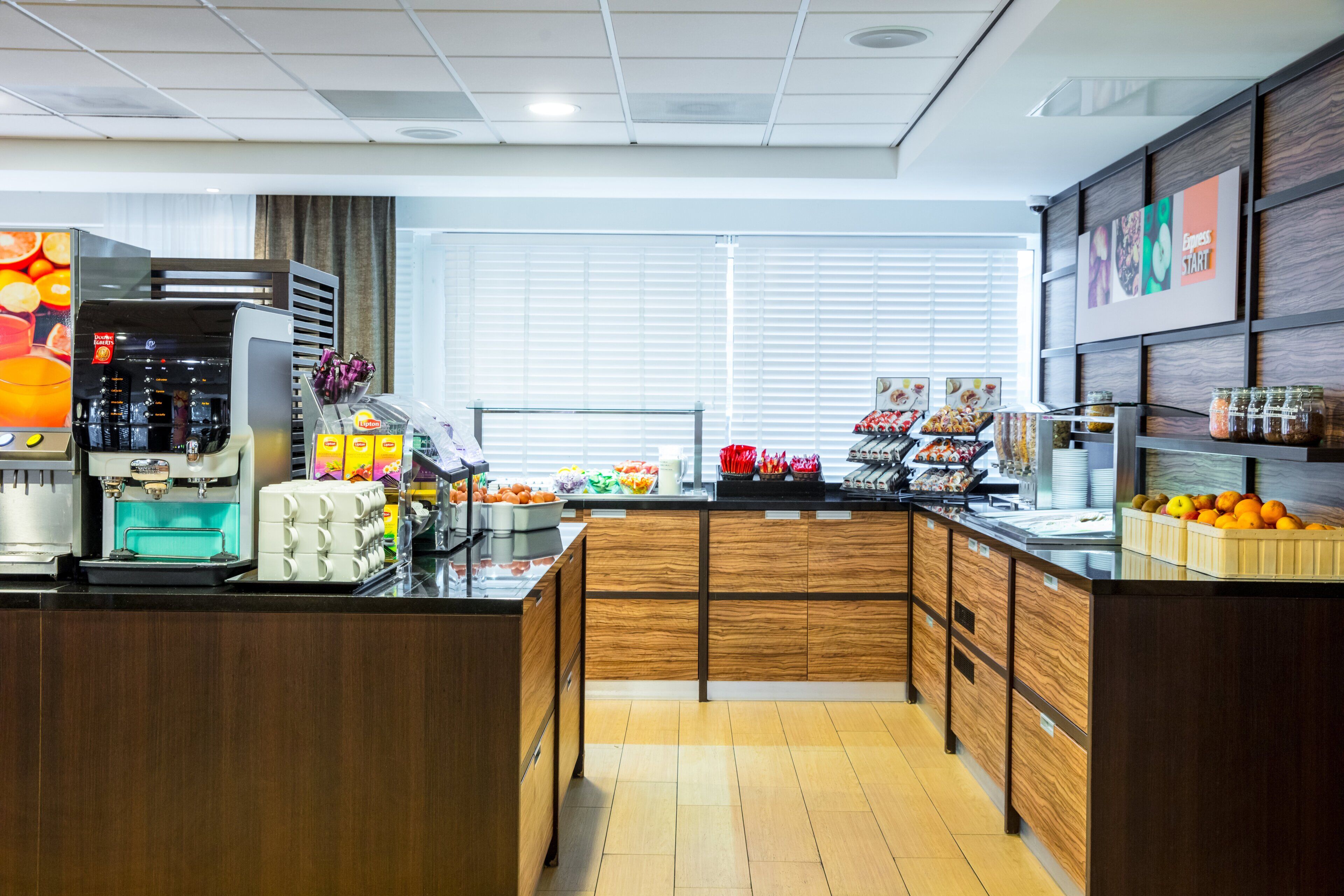 Une cuisine moderne équipée d’une machine à café, d’un présentoir à fruits et d’une variété de produits alimentaires.