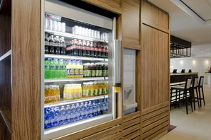 Een automaat gevuld met verschillende drankjes, in een moderne omgeving.