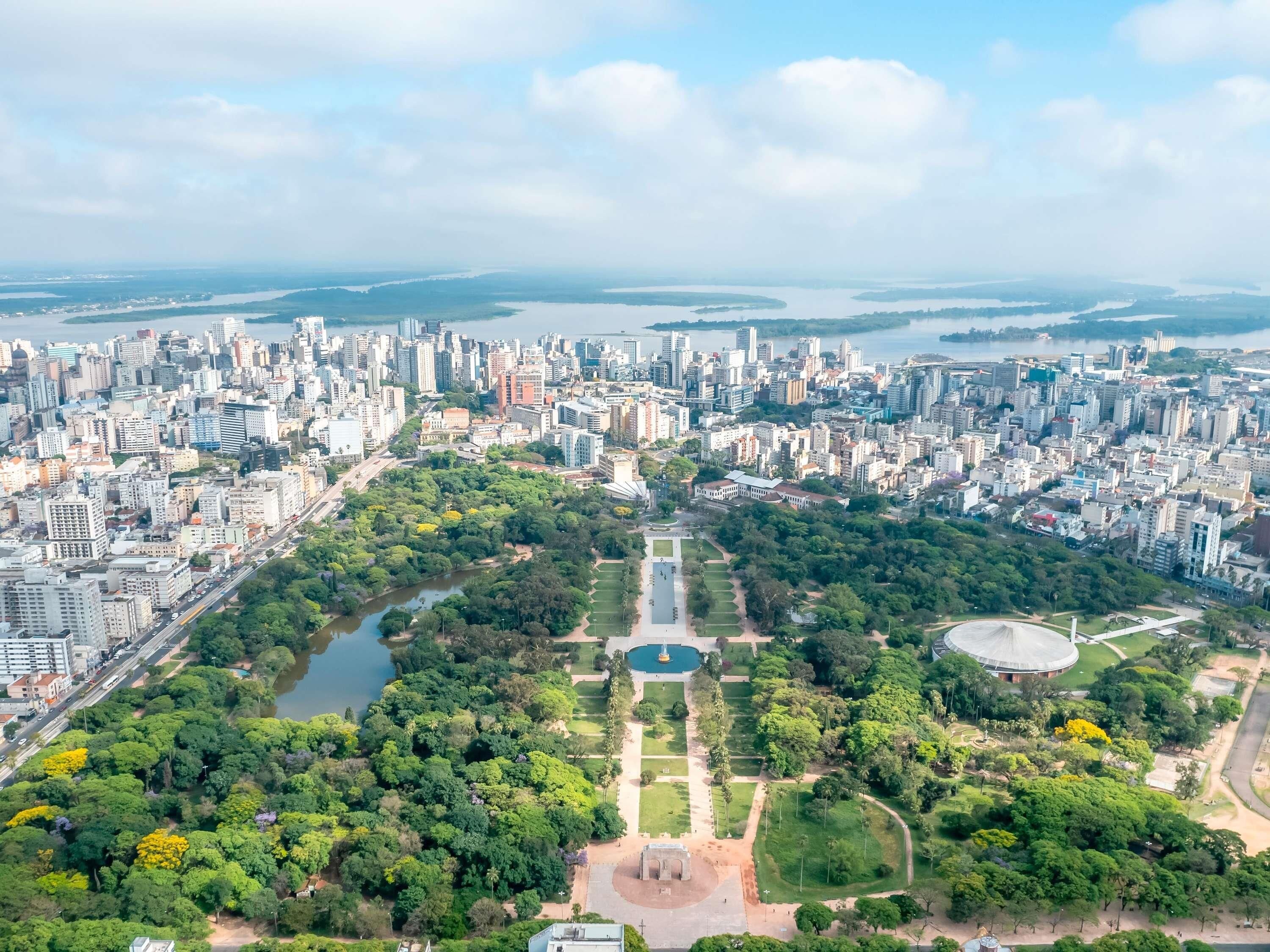 Un paisaje urbano con un parque central, un río y un estadio.