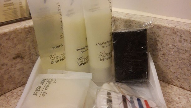 A bathroom counter with toiletries including shampoo, conditioner, body lotion, and a bar of soap. - Novotel Porto Alegre Airport (Porto Alegre)