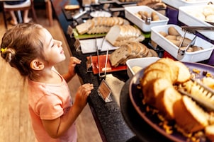 A buffet with various food items including bread, rolls, and other baked goods.
