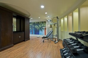 A gym with wooden flooring, exercise equipment, and a large mirror. - Hotel Indigo Atlanta Airport - College Park by IHG (College Park)