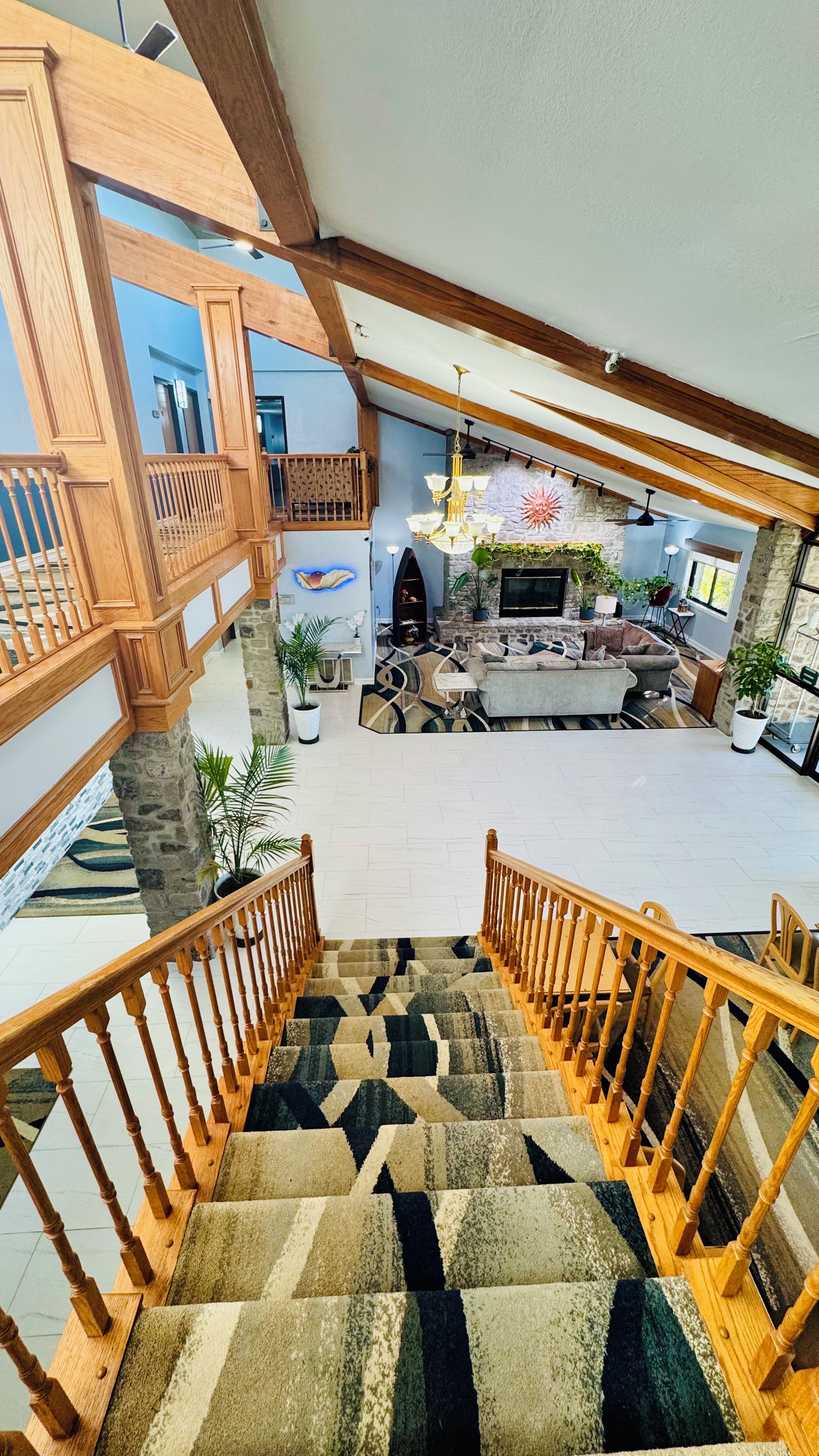 A multi-level interior with a staircase, a fireplace, and a seating area.