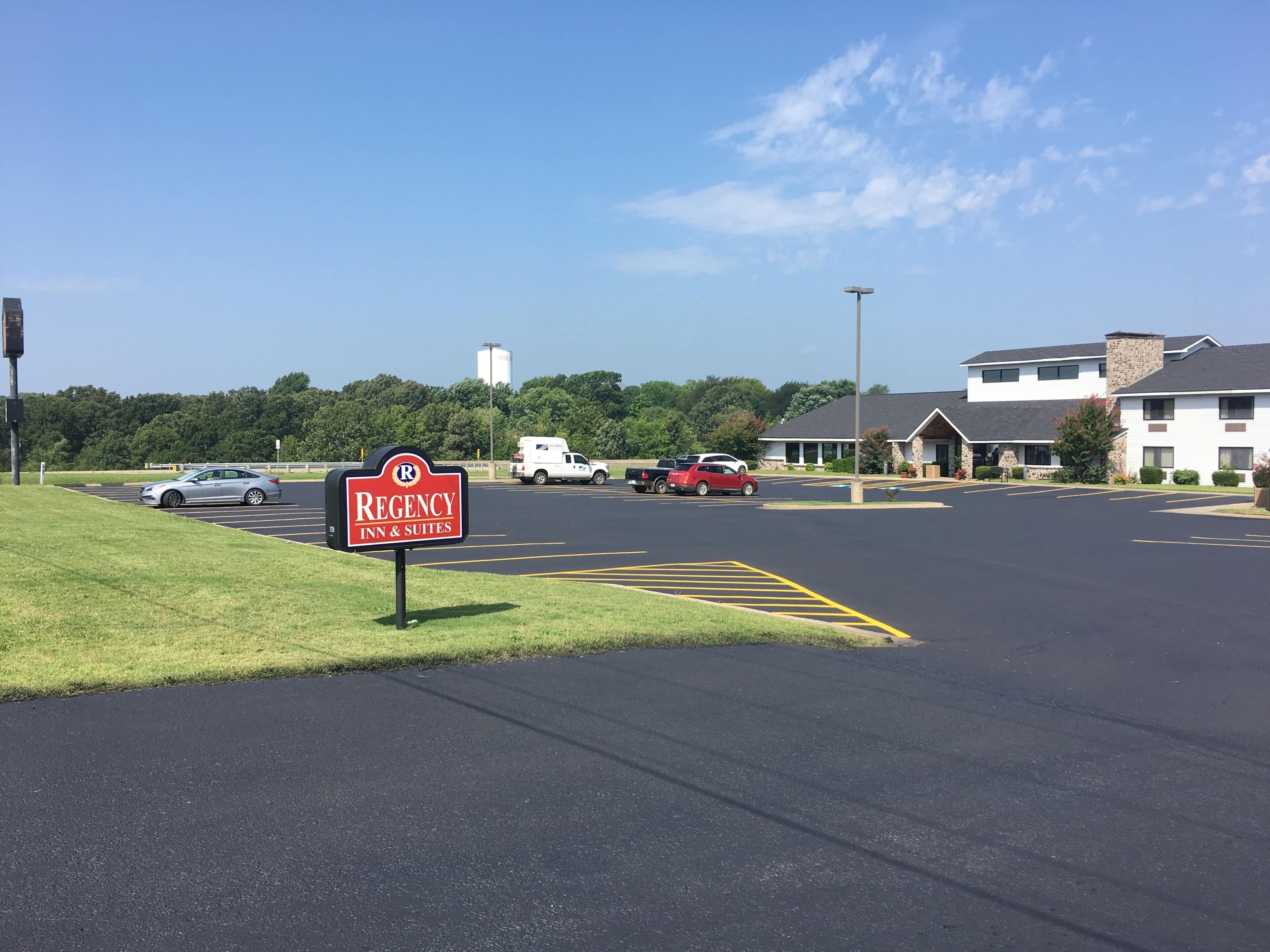 Um estacionamento com placa para Regency Inn & Suites.
