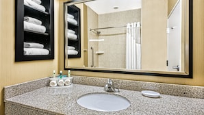 A bathroom with a granite countertop, a sink, a mirror, and a towel rack with neatly folded towels. - Holiday Inn Express & Suites Cotulla by IHG (Cotulla)