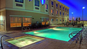 A hotel pool area with a rectangular pool, lounge chairs, and a covered seating area. - Holiday Inn Express & Suites Cotulla by IHG (Cotulla)