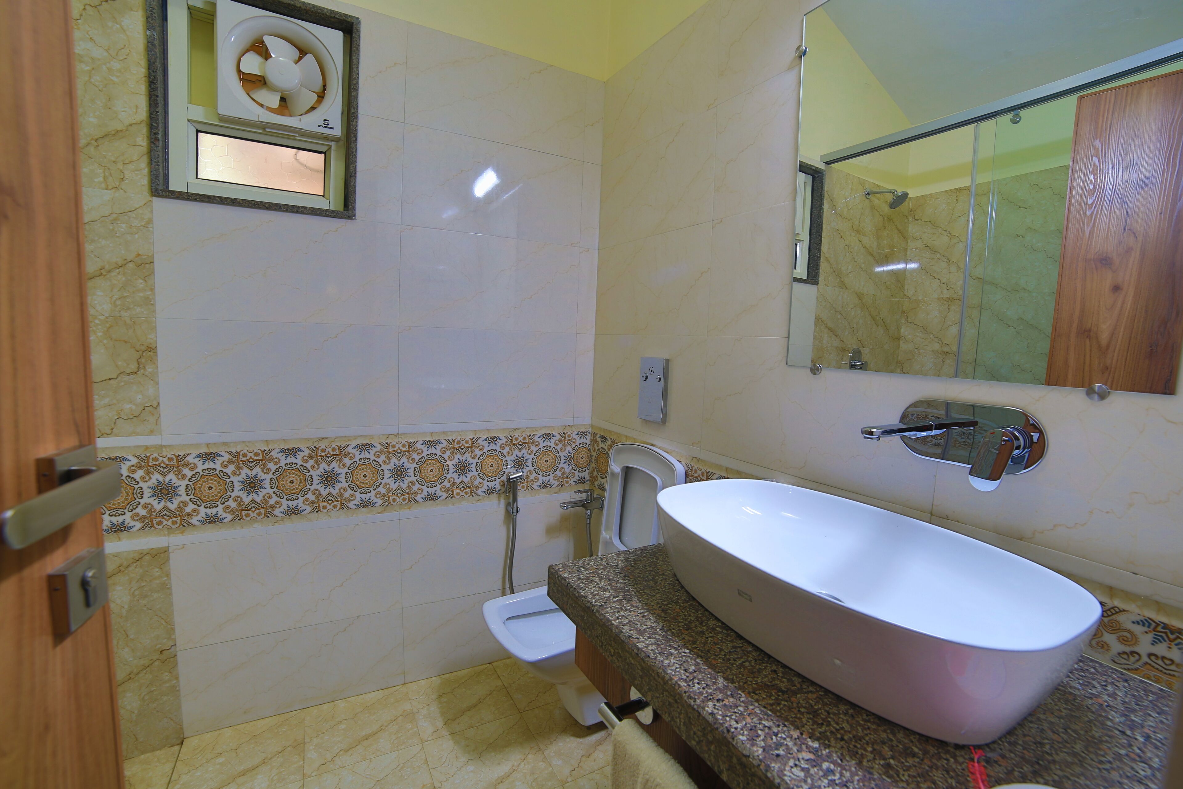 A bathroom with a freestanding bathtub, a toilet, a shower, and a mirror.