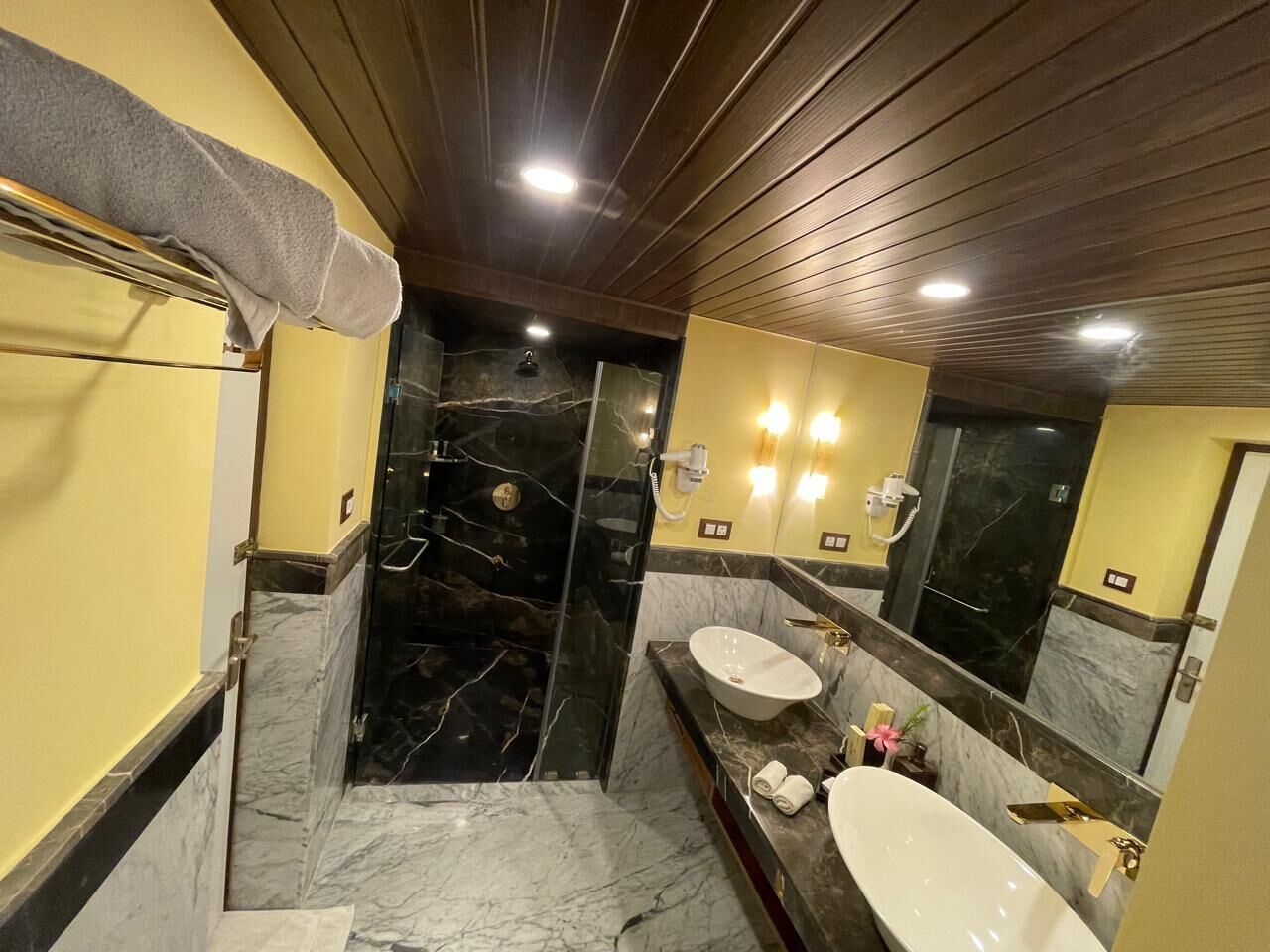 A bathroom with a marble floor, a bathtub, a sink, and a shower.