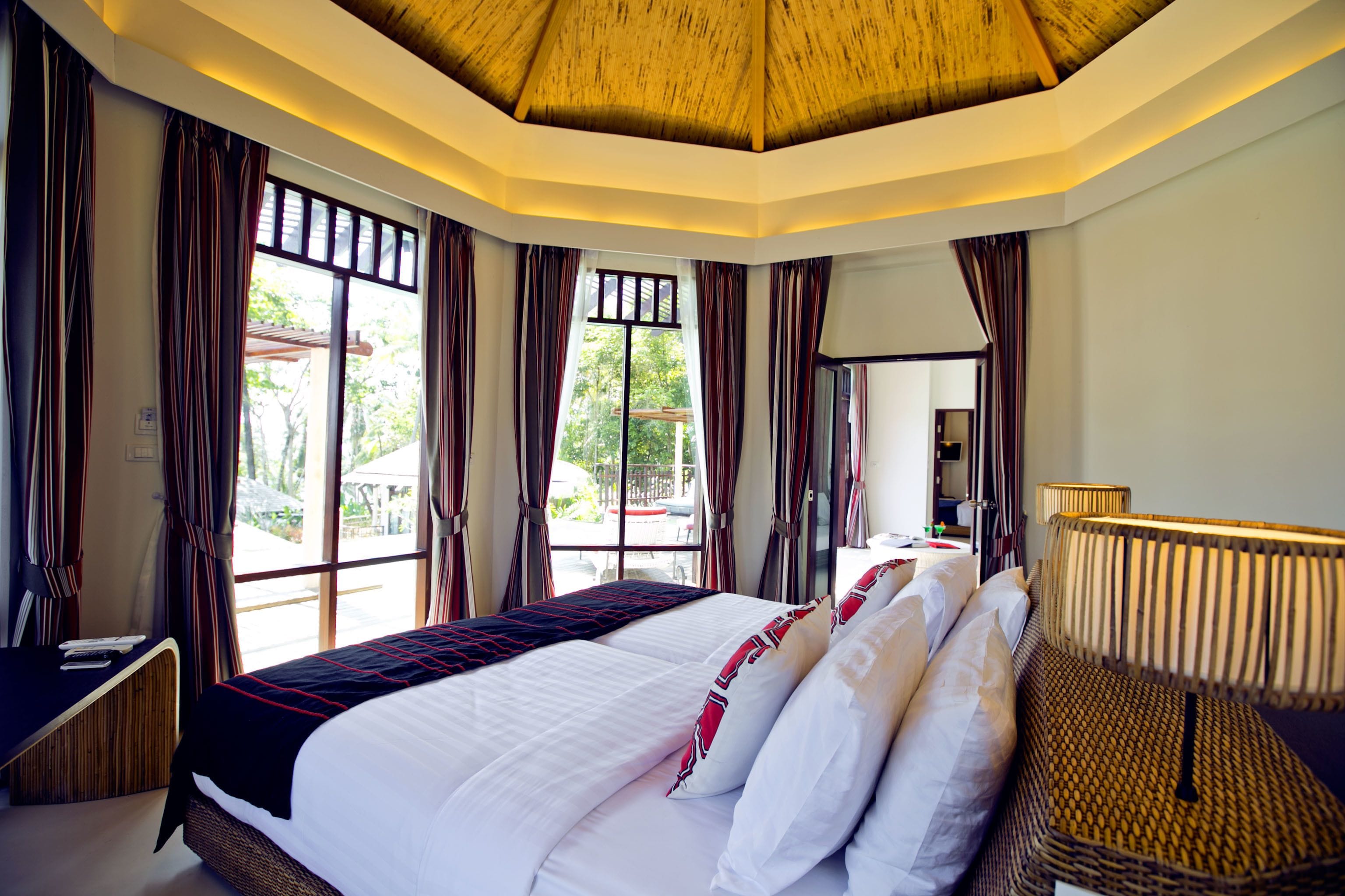 Une chambre d’hôtel avec un grand lit, un bureau et une fenêtre avec des rideaux.