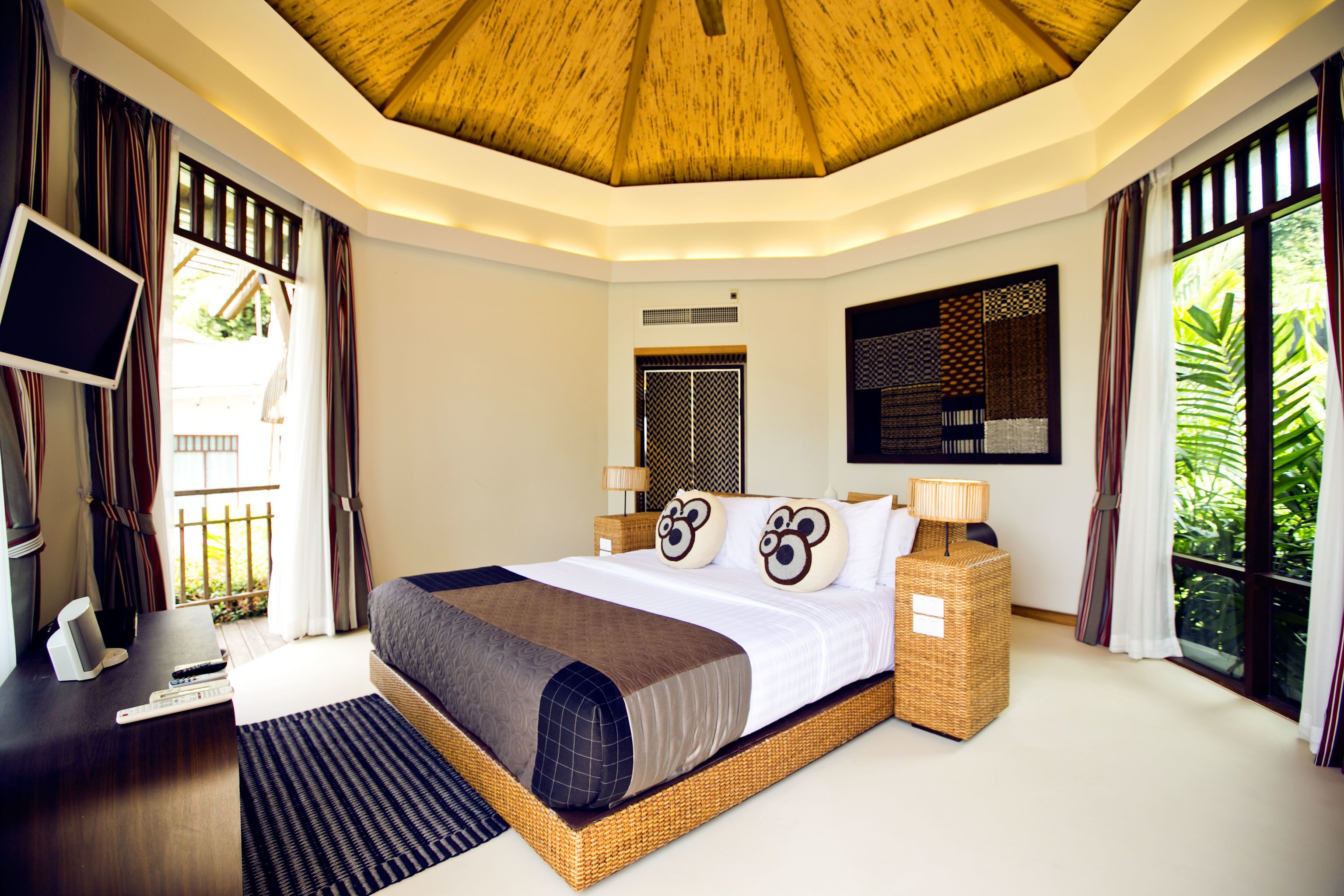 A modern hotel room with a large bed, a TV, and a desk.