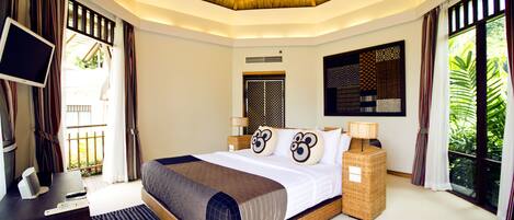 A modern hotel room with a large bed, a TV, and a desk.
