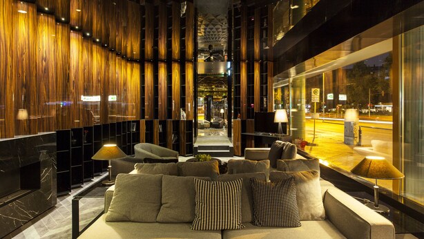 A modern lobby with a sofa, lamps, and a view of the street outside. - Quentin Boutique Hotel (Berlin)