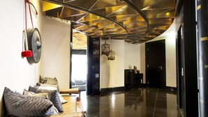 A modern lobby with a curved ceiling, a reception desk, and a seating area with cushions. - Quentin Boutique Hotel (Berlin)