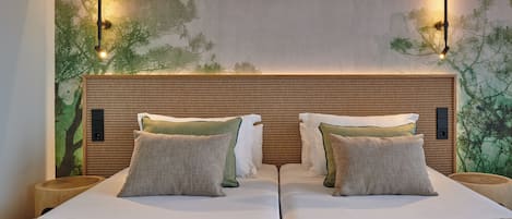A double bed with a wooden headboard, two bedside tables, and wall-mounted lights.